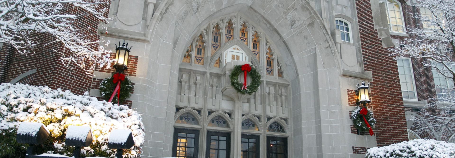 Harkins Hall, Stone and Brick Building, with Three Wreaths and Red Bows on the Front.